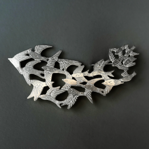 a handmade sterling silver pendant of a flock of starlings in flight, murmuration collection, saw pierced, hand engraved, statement piece, made in glasgow scotland