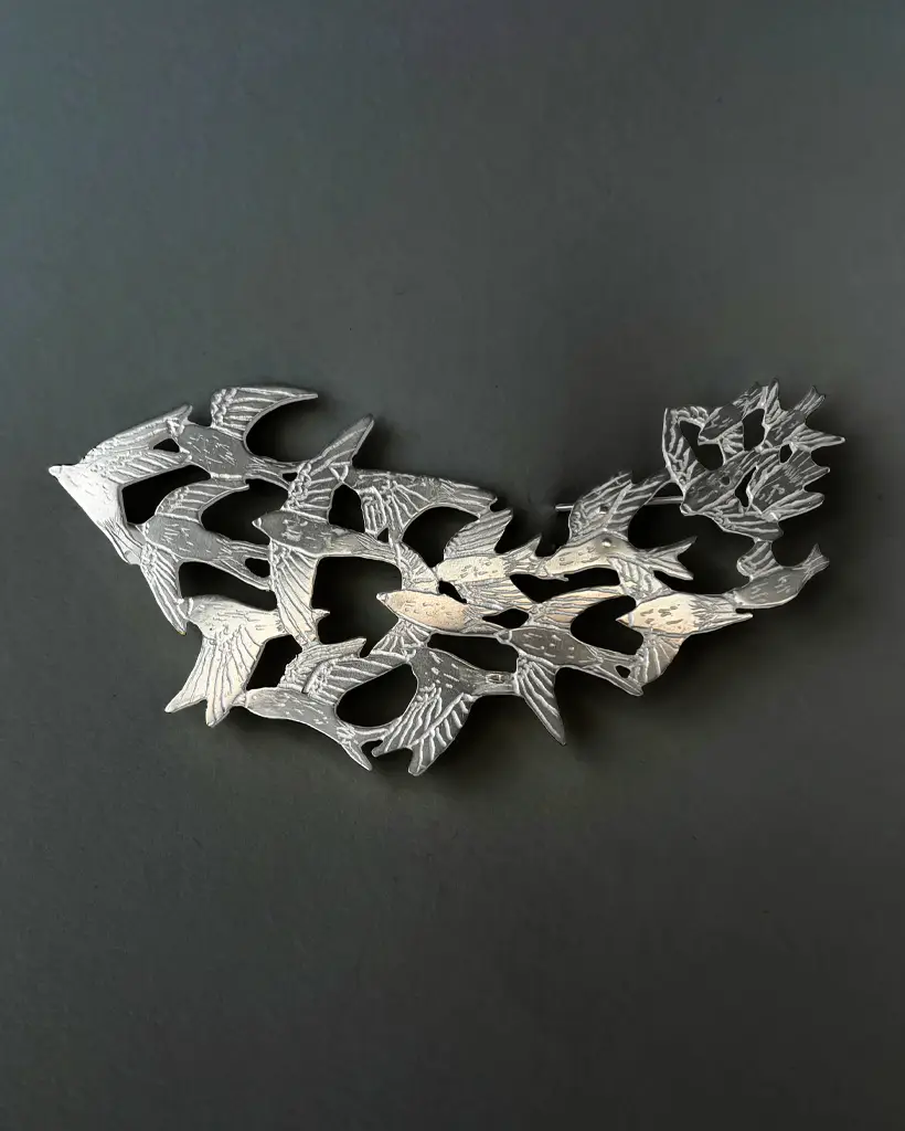 a handmade sterling silver pendant of a flock of starlings in flight, murmuration collection, saw pierced, hand engraved, statement piece, made in glasgow scotland
