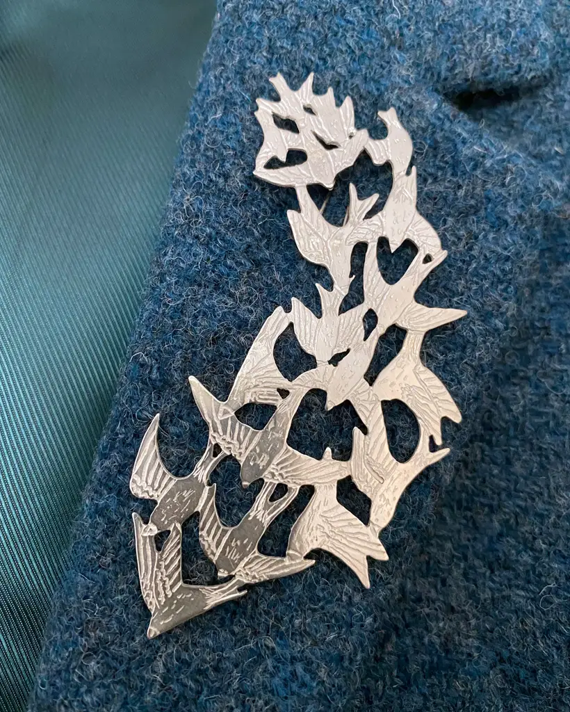 a handmade sterling silver pendant of a flock of starlings in flight, murmuration collection, saw pierced, hand engraved, statement piece, made in glasgow scotland