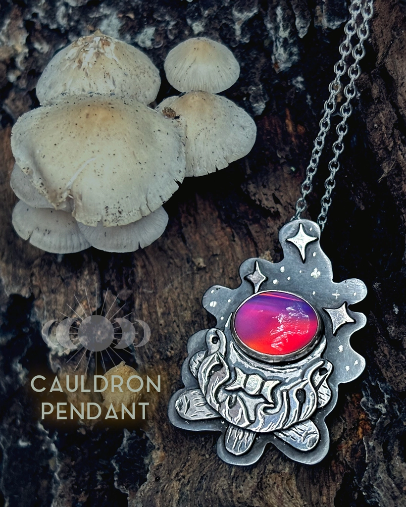Oxidised sterling silver Cauldron Pendant with a glowing pink Aurora Opal, engraved cauldron and stars, on its chain