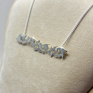 Front view of a handmade sterling silver bar necklace depicting a textured flock of flying birds, designed by Stacy Bias Jewellery on a cream display stand.