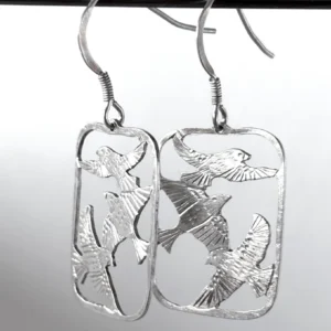 Close view of sterling silver three bird drop earrings, saw-pierced starlings in flight within open frames