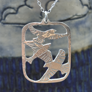 Artisan handmade sterling silver pendant featuring three hand-engraved flying birds in a cutout frame, crafted by Stacy Bias Jewellery in Glasgow, Scotland.
