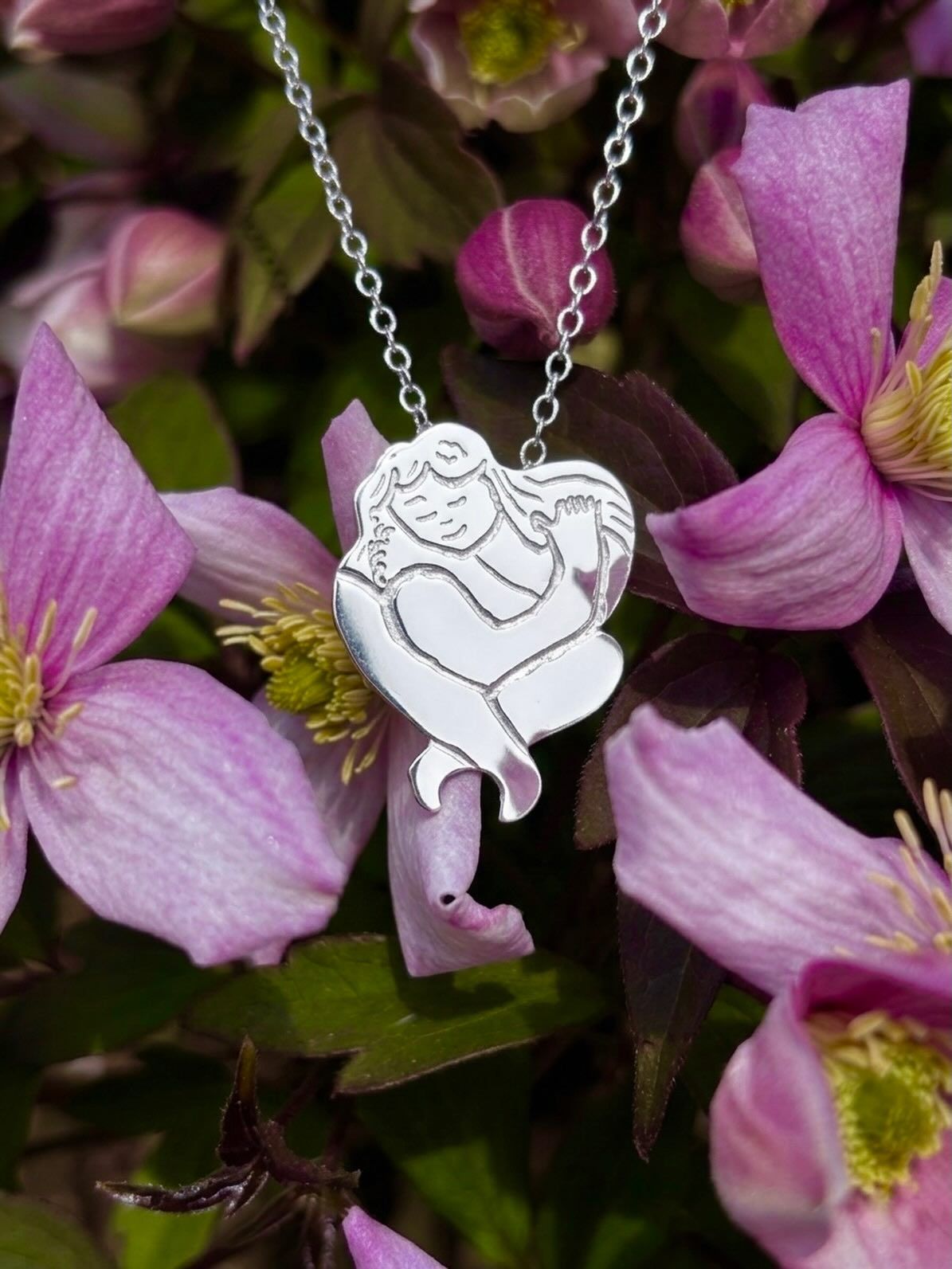 Handmade Sterling Silver Self Hug Pendant by Stacy Bias Handmade sterling silver self love pendant shaped like a figure hugging itself, hand engraved, styled with flowers