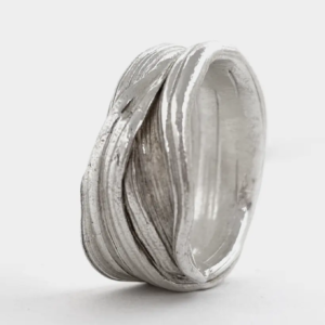 Chunky sterling silver wave ring with folded, layered ridges made by the Mitsuro Hikime wax technique, on white