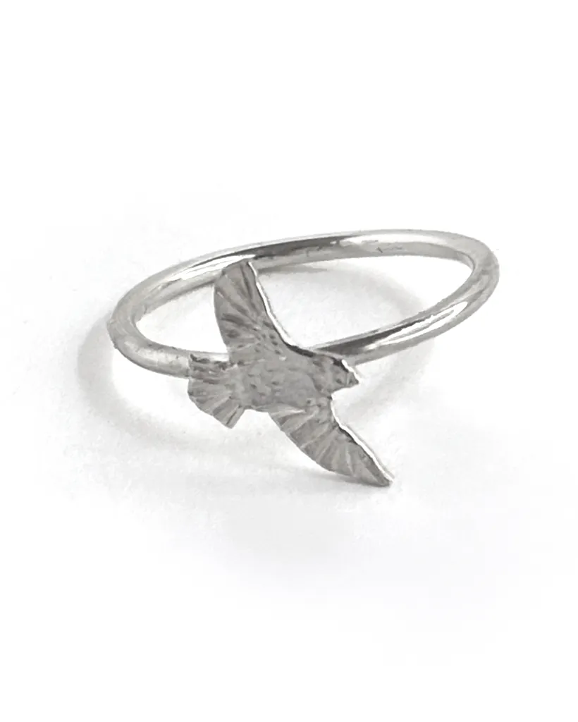 Single sterling silver bird ring on a slim band, an engraved bird diving with wings swept down, on white