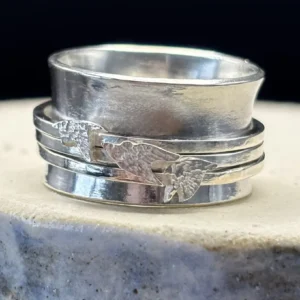 Handmade sterling silver spinner ring, wide band with three slim spinning bands each holding an engraved starling