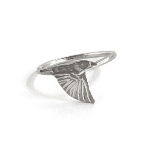 Single sterling silver starling ring on a slim band, an engraved starling banking with one wing angled down