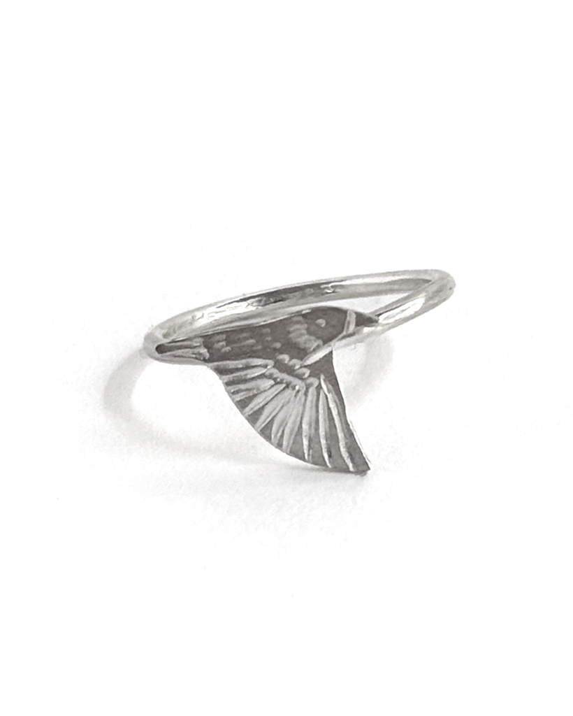 Single sterling silver starling ring on a slim band, an engraved starling banking with one wing angled down