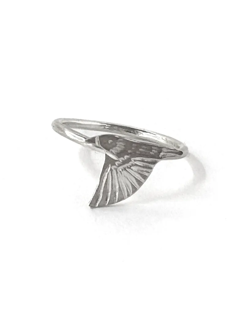 Single sterling silver starling ring on a slim band, an engraved starling diving with wings swept down, on white