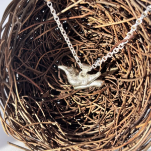 a water cast 925 sterling silver pendant in the shape of a bird and branch