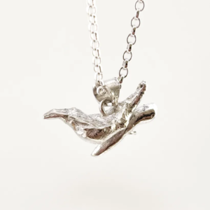 a water cast 925 sterling silver pendant in the shape of a bird and branch