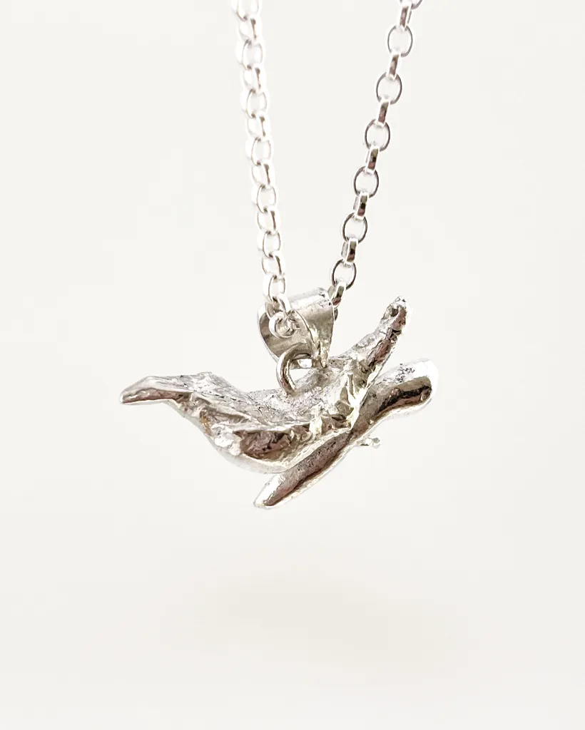 a water cast 925 sterling silver pendant in the shape of a bird and branch