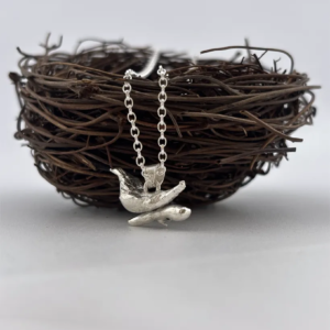 a water cast 925 sterling silver pendant in the shape of a bird and branch