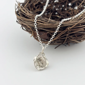 a water cast 925 sterling silver pendant in the shape of a birds nest with eggs