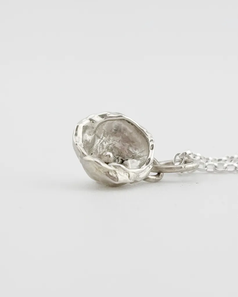 a water cast 925 sterling silver pendant in the shape of a birds nest with eggs