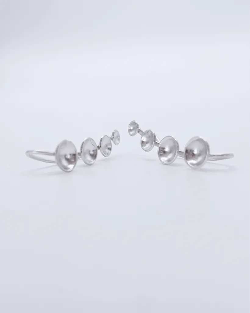 Front view of 925 sterling silver ear climber earrings, showing a mirrored pair with domed dots cascading in a gentle curve from large to small.