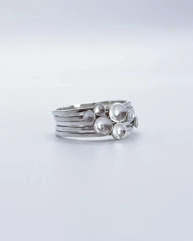 Polished sterling silver Murmuration Dot stacking ring set, bright silver bands with domed dots clustered as a flock