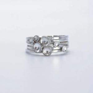 Polished sterling silver Murmuration Dot rings stacked head-on, domed dots clustered into a flock of birds in flight