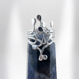 Artisan handmade sterling silver Squiggle ring with fluid, organic teardrop tendrils climbing from a multi-strand band, displayed on a dark crystal point.