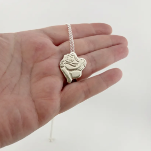 Chunky silver Self Love pendant necklace held in an open hand to show scale. Handcrafted by Stacy Bias.