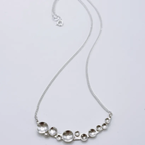Bright silver Murmuration Dot Arc pendant necklace on fine curb chain with clasp. Handcrafted by Stacy Bias.