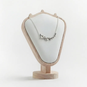 Oxidised silver Murmuration Dot Arc necklace displayed on a wooden and cream neck bust. Handcrafted by Stacy Bias.